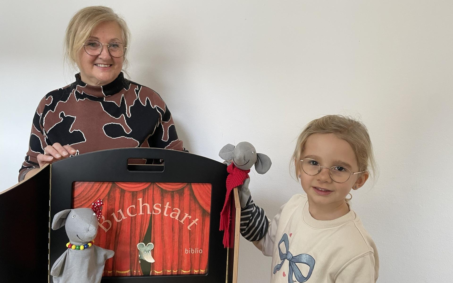 zwei Handpuppen vor Bühne und ein Kind