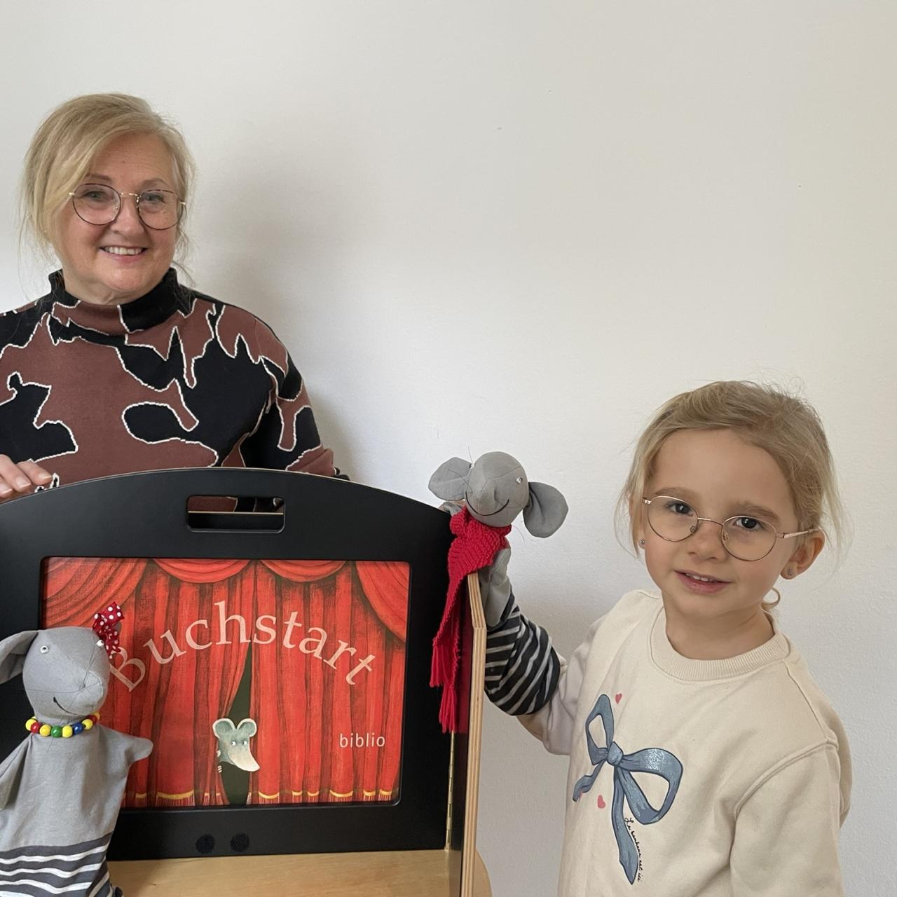 zwei Handpuppen vor Bühne und ein Kind