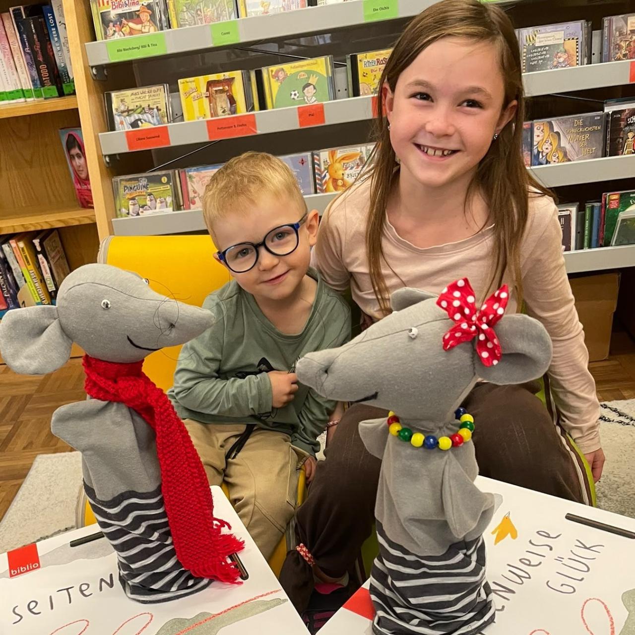 2 Kinder posieren mit Handpuppen